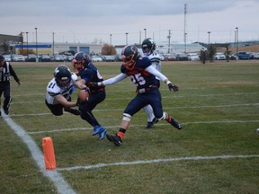 Paul Condon dives through Cavaliers defence, scoring a touchdown for the Mustangs during the playoff game between the Airdrie schools on September 21.