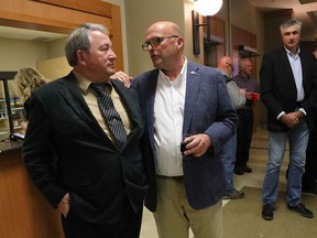 Prince Edwad County mayor (elect) Steve Ferguson (right) shares a word with challenger Terry Shortt after the results of Monday's municipal election were released at the Wellington and District Community Centre. Outgoing Hillier councillor Ernie Margetson looks on. BRUCE BELL