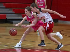 Julia Hesmer (left) of the St. John's Eagles and Mya Padusenko of the Paris Panthers chase down the ball during a high school senior girls basketball game on Tuesday in Paris, Ontario.