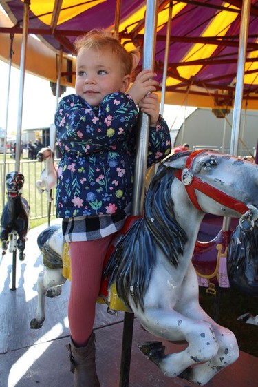 Two-year-old Riley Bateson takes a spin on midway staple, the merry-go-round, on Sunday at the Burford Fair. Michelle Ruby