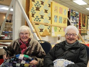Sisters Thelma Pite, 94 (left), and Hilda Roswell, 95, who have entered their handmade quilts in competitions at the Burford Fair since the 1960s, show of this year's entries at the fair on Sunday. Michelle Ruby