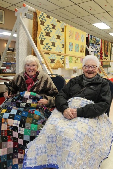 Sisters Thelma Pite, 94 (left), and Hilda Roswell, who have entered their handmade quilts in competitions at the Burford Fair since the 1960s, show of this year's entries at the fair on Sunday. Michelle Ruby