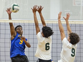 Karsten Ottey (left) of the BCI Mustangs spikes the ball as Pacheco Deleon (centre) and Jaden Chagnon of the St. John's College Green Eagles go up to block during a high school senior boys volleyball match on Tuesday at SJC. Brian Thompson/Brantford Expositor/Postmedia Network