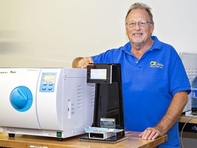 Frank Pedersen, CEO of Alpha Micro Tech Inc. shows one of his units alongside a dental sterilization machine (left) in Brantford.