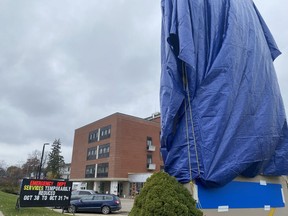 A large sign at Norfolk General Hospital in Simcoe was covered with a tarp on Monday. A smaller sign announced the temporary closure of the hospital's emergency department from Sunday until 7 p.m. on Monday.