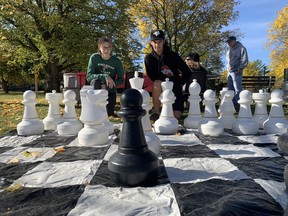 Grady McCall, 13, and Antony DeGrandis, 14, look to make a move during a chess match at the official opening of the Preston Park playground on Saturday.  Vincent Ball