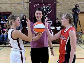McGregor grad Bridget Carleton takes part in a ceremonial tipoff with senior girls’ basketball captains Avery Krouse, left, of the McGregor Panthers and Brittany Pegg of the Lambton-Kent Cardinals during a tribute night at John McGregor Secondary School in Chatham, Ont., on Friday, Oct. 28, 2022. A banner honouring Carleton's successful basketball career now hangs in the Larry Lahey Athletic Centre. (PHOTO Ellwood Shreve/Chatham Daily News/Postmedia Network)
