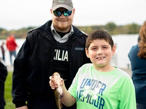 CPS Auxiliary member Alexandre D'Aoust with one of the many youths at the Kids, Cops and Fishing event.Handout/Cornwall Standard-Freeholder/Postmedia Network