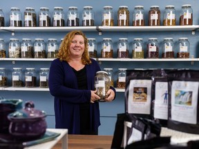 Angela Graye poses with a jar of tea at Still Water Tea in Cochrane on Friday, Oct. 21, 2022. Graye opened her brick-and-mortar store in Historic Downtown on Oct. 11.