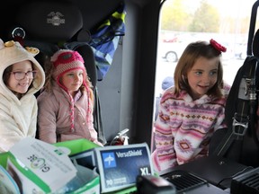 First grade students Charlee, Lexi, and Sophie sit in the backseat of a fire truck as part of Fire Prevention Week celebrations at Ecole Alliance St-Joseph.  Mia Jensen