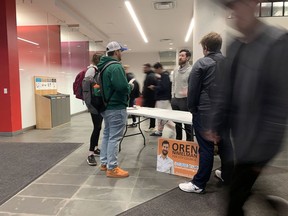 Portsmouth District city council candidate Oren Nimelman talks with St. Lawrence College students at an unofficial information table in the college's lobby on Tuesday.