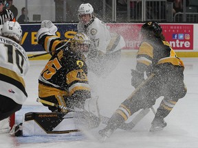 Hamilton Bulldogs defenceman Lucas Moore snows his goaltender, Matteo Drobac, as Kingston Frontenacs forwards Chris Thibodeau, left, and Owen Outwater look for the puck during Ontario Hockey League action at the Leon's Centre on Friday. Kingston won the game, 4-2.