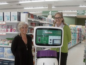 Exeter Guardian Pharmacy cosmetician Mychelle Primeau, left, and manager Angela McLean with a new feature at the store, a robot named Peanut that helps customers find the items they are looking for.