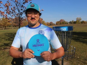 Patrick McCauley of Peace Bridge Disc Golf holds a disc while standing next to one of the baskets set up Saturday at a disc golf course in Sarnia's Centennial Park.