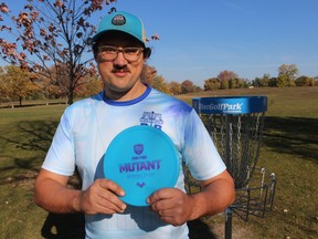 Patrick McCauley, with Peace Bridge Disc Golf, holds a disc while standing next to one of the baskets installed Saturday on a disc golf course in Sarnia's Centennial Park.