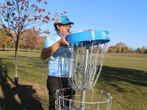 Patrick McCauley, with Peace Bridge Disc Golf, installs a basket Saturday on a disc golf course in Sarnia's Centennial Park.