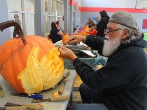 Carver Jim Vergunst works on a large pumpkin Saturday at the Fiery Faces Family Day held at the YMCA Petrolia.