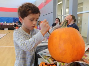 Alexander Edrando, 5, carves a pumpkin Saturday at the Fiery Faces Family Day held at the YMCA Petrolia. The Fiery Faces carved pumpkin display at The Discovery site in Petrolia ran Friday to Sunday, 6 p.m. to 9 p.m. The event is a fundraiser for the Petrolia Kiwanis.