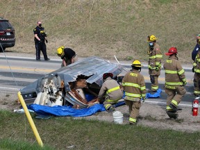 Firefighters inspect a damaged boat after a collision on Oil Heritage Road near Discovery Line on Friday, April 23, 2021, in Petrolia.  Terry Bridge/Sarnia Observer/Postmedia Network