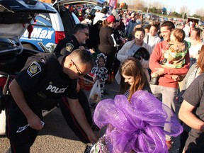 Sarnia Police constables Nelson Amaral, front, and Giovanni Sottosanti, hand out stickers and treats at the end of the Trunk or Treat circuit at Hiawatha Horse Park Oct. 29, 2022. (Tyler Kula/ The Observer)
