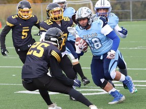 Mattaeus Grossi, right, of St. Benedict Bears, attempts to evade tacklers during football action against the Lively Hawks at James Jerome Sports Complex in Sudbury, Ont. on Friday October 7, 2022. John Lappa/Sudbury Star/Postmedia Network