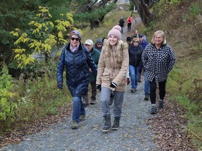 Community members take part in a guided hike at the 10-year celebration and official opening of the Fisher Wavy Trail section of the Junction Creek Waterway Park on Thursday.