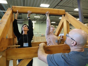 Al Therrien, a professor and coordinator of the carpentry program at College Boreal, looks on as Renee Joly, left, and Jennifer Gibson assemble a timber structure at the college in Sudbury, Ont. on Thursday October 27, 2022. About 30 Grade 7 and 8 cooperative education teachers and guidance counsellors from various Conseil scolaire catholique Nouvelon schools participated in a training session on skilled trades at College Boreal. A release issued by the school board said, "During this session, offered jointly by College Boreal and CSC Nouvelon, participants will be informed about future employment opportunities, transferable skills, multiple post-secondary pathways and specialized high school programs (SHSM, COOP/OYAP, DCP and EL)." John Lappa/Sudbury Star/Postmedia Network