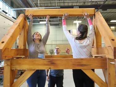 Al Therrien, middle, a professor and coordinator of the carpentry program at College Boreal, looks on as Tammy Dwyer, left, and Melanie Savoie disassemble a timber structure at the college in Sudbury, Ont. on Thursday October 27, 2022. About 30 Grade 7 and 8 cooperative education teachers and guidance counsellors from various Conseil scolaire catholique Nouvelon schools participated in a training session on skilled trades at College Boreal. A release issued by the school board said, "During this session, offered jointly by College Boreal and CSC Nouvelon, participants will be informed about future employment opportunities, transferable skills, multiple post-secondary pathways and specialized high school programs (SHSM, COOP/OYAP, DCP and EL)." John Lappa/Sudbury Star/Postmedia Network