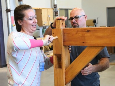 Al Therrien, a professor and coordinator of the carpentry program at College Boreal, looks on as Melanie Savoie, of Ecole secondaire catholique l'Horizon, assembles a timber structure at the college in Sudbury, Ont. on Thursday October 27, 2022. About 30 Grade 7 and 8 cooperative education teachers and guidance counsellors from various Conseil scolaire catholique Nouvelon schools participated in a training session on skilled trades at College Boreal. A release issued by the school board said, "During this session, offered jointly by College Boreal and CSC Nouvelon, participants will be informed about future employment opportunities, transferable skills, multiple post-secondary pathways and specialized high school programs (SHSM, COOP/OYAP, DCP and EL)." John Lappa/Sudbury Star/Postmedia Network