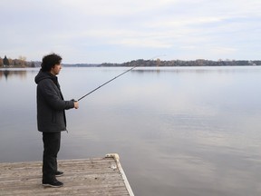 Ariel Retamal tries his luck at fishing at Ramsey Lake in Sudbury, Ont. on Monday October 31, 2022. John Lappa/Sudbury Star/Postmedia Network