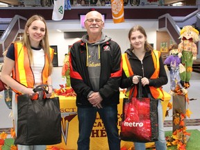 Zoë Brazeau, from left, Grade 11 student at École secondaire catholique Thériault, with Jim Young of the Timmins Food Bank and Isabella MacPhail, Grade 9 Thériault student, get ready for "Trick or Donate." The high school has been running the Halloween food drive since 2014. Students in safety vests will be collecting non-perishable foods door-to-door in the city's north end and Mountjoy area from 5 to 8 p.m. on Monday.
NICOLE STOFFMAN/The Daily Press