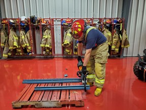 Firefighter Jeff Crawford demonstrates the new cutter that the department obtained. The advancement in equipment will help the local department when they are called to extricate a person from a vehicle in the event of an accident. This cutter is technically up to date and provides the most power to cut vehicles.