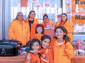 ORANGE SHIRT DAY Members of the Missanabie Cree First Nation (L-R) Gloria Harris, April Wesley, Brie Nemeth and Jana Harris along with their children spread the message that every child matters. It is important for everyone to learn about and understand the origin of the orange shirt says Harris.  The group set up their food, refreshment and information booth in front of their Queen Street office on Friday for the National Day for Truth and Reconciliation and to honour all residential school survivors.  BOB DAVIES