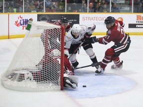Cam Allen (left) and Cedricson Okitundu (right) tie up Sam Sedley (centre) as goaltender Jacob Oster sprawls in the crease as the Owen Sound Attack host their Midwest Division rival the Guelph Storm inside the Harry Lumley Bayshore Community Centre on Saturday, Oct. 29, 2022. Greg Cowan/The Sun Times