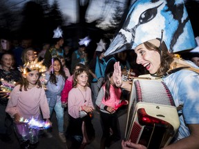 A performer dressed as a Blue jay leads kids in a sing-a-long as they participate in the Department of Illumination's 10th annual Firelight Lantern Festival parade on Saturday in Picton, Ontario. ALEX FILIPE