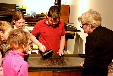 Stratford-Perth Museum volunteer Brenda Smith teaches grade 5 students from Milverton Public School how to ink a printing plate before using it to press a National Day for Truth and Reconciliation design onto an orange t-shirt during a field trip to the museum Tuesday. Galen Simmons/The Beacon Herald/Postmedia Network