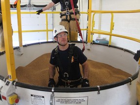Sarnia Firefighter Shawn Schinkel, is lowered into grain during rescue training Tuesday at the firehall on Wellington Street. City firefighters are being trained in grain bin rescues using a specialized trailer from the Canadian Agriculture Safety Association.
Paul Morden/Postmedia