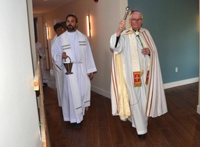 Bishop Douglas Crosby, Oblate of Mary Immaculate, ninth bishop of the Diocese of Hamilton, right, blesses the newly built St. Mary's Rectory with Father Wojtek Kuzma, priest of St. Mary's Catholic Church, in Owen Sound on Saturday, November 12 2022 .