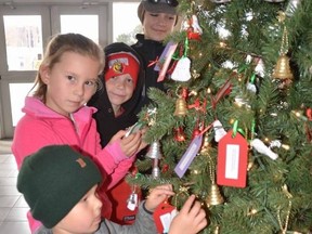Youngsters hang bells on the Bells of Christmas tree at the Harry Lumley Bayshore Community Centre on Saturday, November 12, 2022. From front to back are Everett O'Hara, 3, Nora Bettridge, 8, Caellum Walker, 8, and Madison Walker, 12. The initiative sees members of the public take a bell, which has the first name and gift suggestions for a senior at a local long-term care home who rarely if ever gets guests during the year. Those who take a bell then purchase a gift and place it in a collection box at the Lumley-Bayshore to be distributed to the seniors at Christmas.