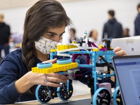 Olivia Flores, 14, of St. Mary's Catholic Secondary School in Woodstock, is studying a robot built by her team as part of the Oxford Robotics Challenge for Youth in Woodstock on Tuesday.  (Mike Hensen / Postmedia Network)