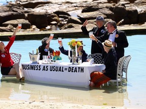 Climate activists from Extinction Rebellion stage a piece of street theatre on Water Day during COP27, to highlight the fact that fossil fuel "Business as Usual " is leading to climate disasters, such as sea level rise in Cape Town, South Africa, November 14, 2022. REUTERS/Esa Alexander
