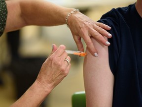 A registered nurse administers a flu shot on Oct. 17. Azin Ghaffari/Postmedia