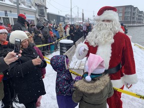Santa Claus spent a few minutes speaking with children before he and Mrs.  Claus got on a horse-drawn sleigh to participate in Port Dover's Christmas Fest and Santa Claus Parade on Nov. 19. Vincent Ball
