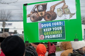 A protester holds a critical sign of Ontario Premier Doug Ford during a rally opposing Bill 23 in Stratford on Friday.  (Chris Montanini/Stratford Beacon Herald)