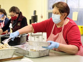 Grace Magliaro (right), Jane Butterman and Jan Brosseau package meals during Interfaith Caring Kitchen’s annual Christmas dinner at the Spirit & Life Centre in Chatham. Mark Malone/File photo