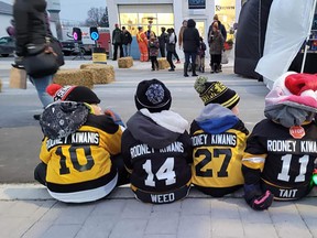 Members of the West Lorne minor hockey program were recruited to collect items for the Caring Cupboard during the Rodney Night Market on Nov. 19. Some of the hockey players took a break while sitting on a curb to watch the vendors and shoppers. Larry Schneider photo