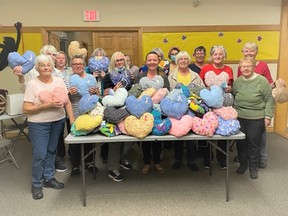 The Dutton library knitting group and other community members pose with some of the heart pillows they have created to be donated to St. Joseph's Breast Care Centre to provide comfort for those going through breast cancer surgery. Elgin County Library photo
