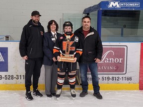 Kincardine coach Travis McKeag, left, looks on as captain Cal McQuillin accepts the championship trophy from branch 309 president Marilyn Scott and Lucknow legion executive member Luke Cranston. Submitted photo.