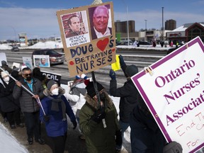 Nurses and their supporters protest Premier Doug Ford and Ontario's Bill 124 on the sidewalk in front of the constituency office of PC MPP for Ottawa West-Nepean Jeremy Roberts in Ottawa, on Friday, March 4, 2022.&ampnbsp;An Ontario court has struck down a bill that limited wages for public sector workers.&ampnbsp;&ampnbsp;THE CANADIAN PRESS/Justin Tang