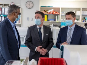Alberta Minister of Health Jason Copping, centre, tours Alberta Precision Laboratories in Calgary with Dr. Dylan Pallai, South Sector Medical Director, Alberta Precision Laboratories, left and Jason Pincock, president and CEO, DynaLIFE Medical Labs on Thursday, June 2, 2022. 
Gavin Young/Postmedia